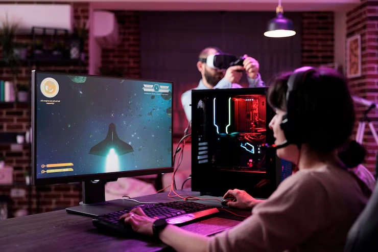 Woman playing space adventure game with VR headset user behind at a Custom Game Development Agency in UK