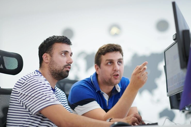 Two developers focused on a screen at a Custom Game Development Agency in UK
